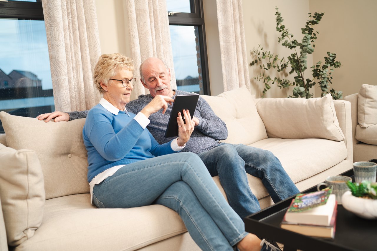 Two people controlling a thermostat with their tablet