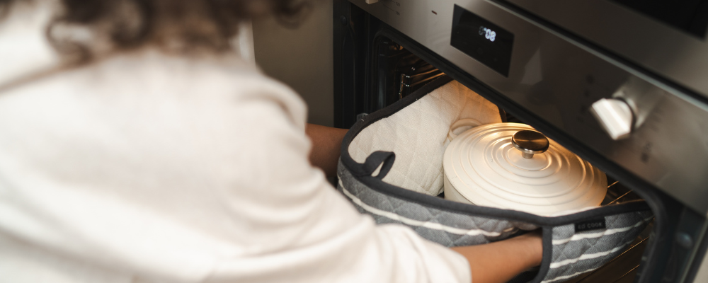 woman taking a dish out of the oven