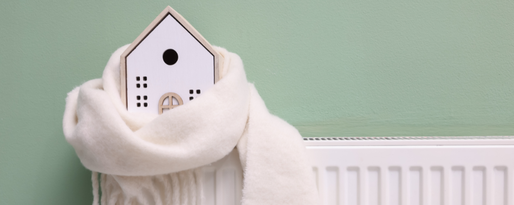 House ornament wrapped in a scarf on a radiator