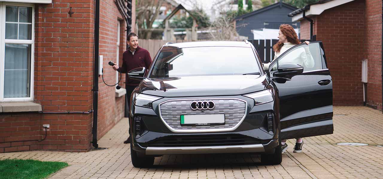 Man and woman charging their electric vehicle